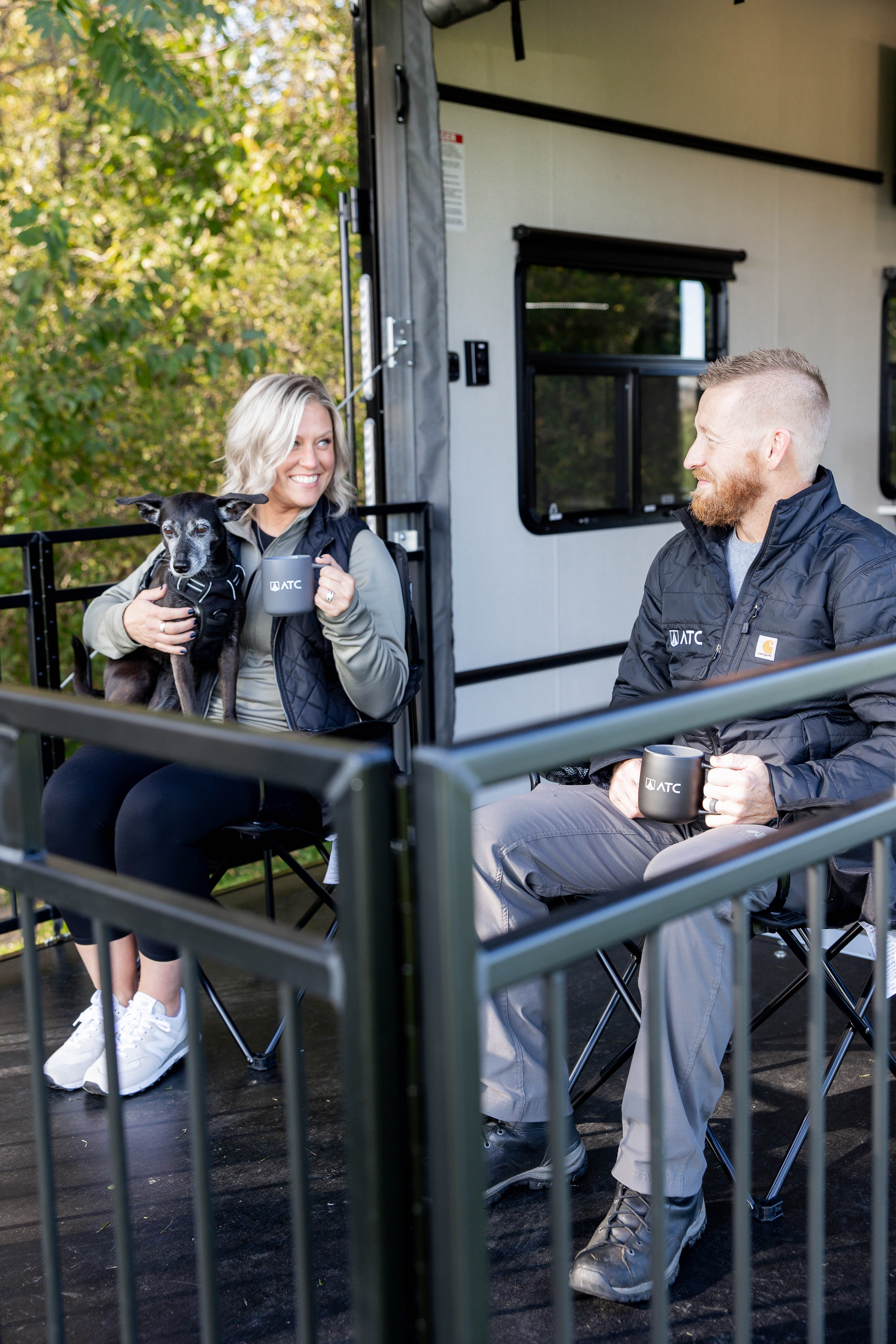 Photo of a couple and a dog on the deck of an ATC toy hauler RV.